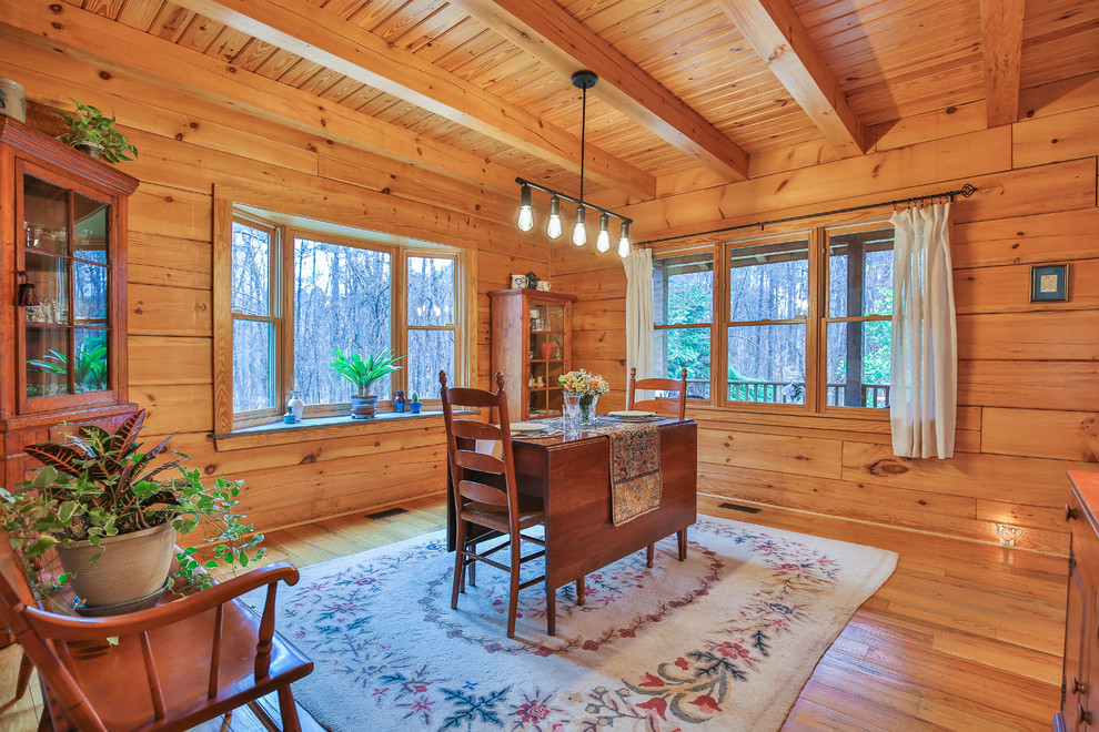 Country dining room in Raleigh with medium hardwood floors and no fireplace.