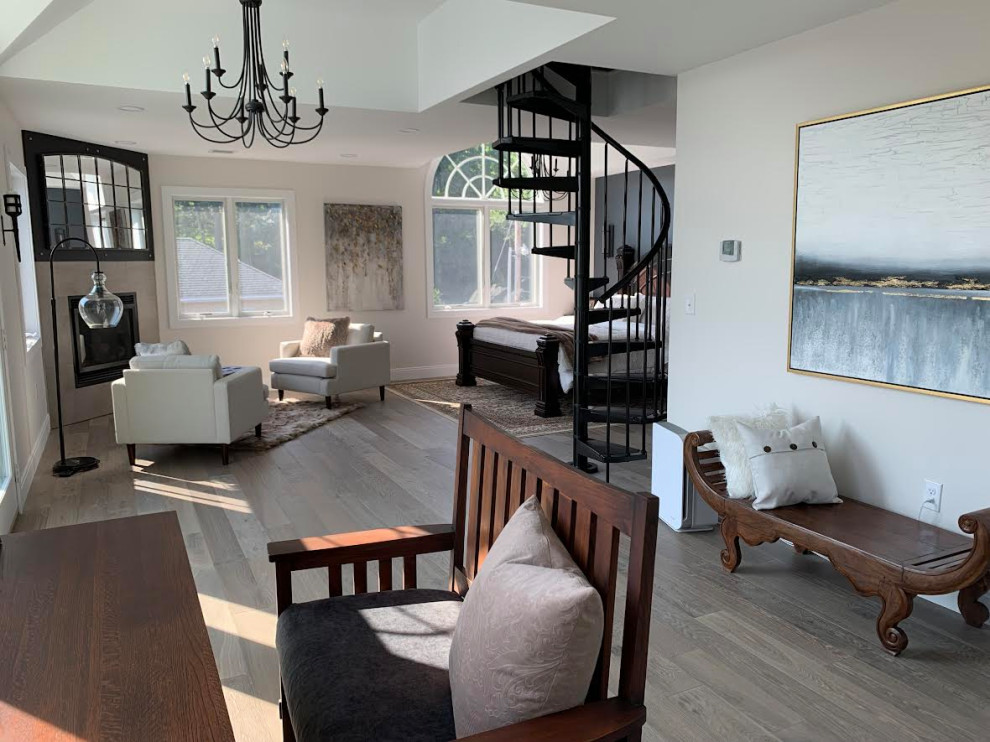 Modernes Hauptschlafzimmer mit bunten Wänden, braunem Holzboden, Eckkamin, gefliester Kaminumrandung, grauem Boden und gewölbter Decke in Boston