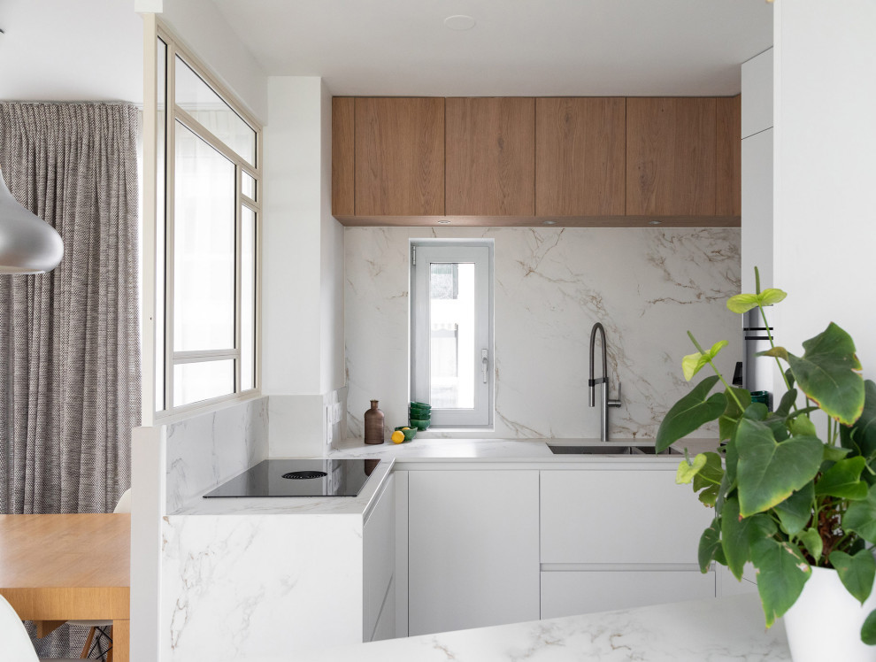 Aménagement d'une cuisine contemporaine avec une crédence en marbre et sol en béton ciré.