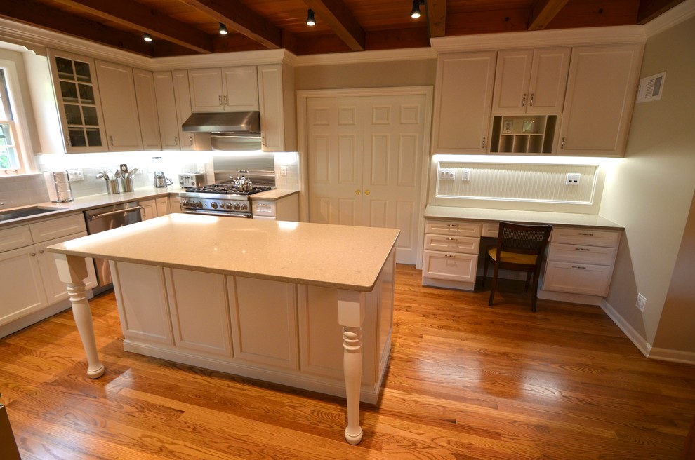 Photo of a large traditional u-shaped separate kitchen in Chicago with an undermount sink, flat-panel cabinets, white cabinets, quartzite benchtops, white splashback, glass tile splashback, stainless steel appliances, medium hardwood floors and with island.