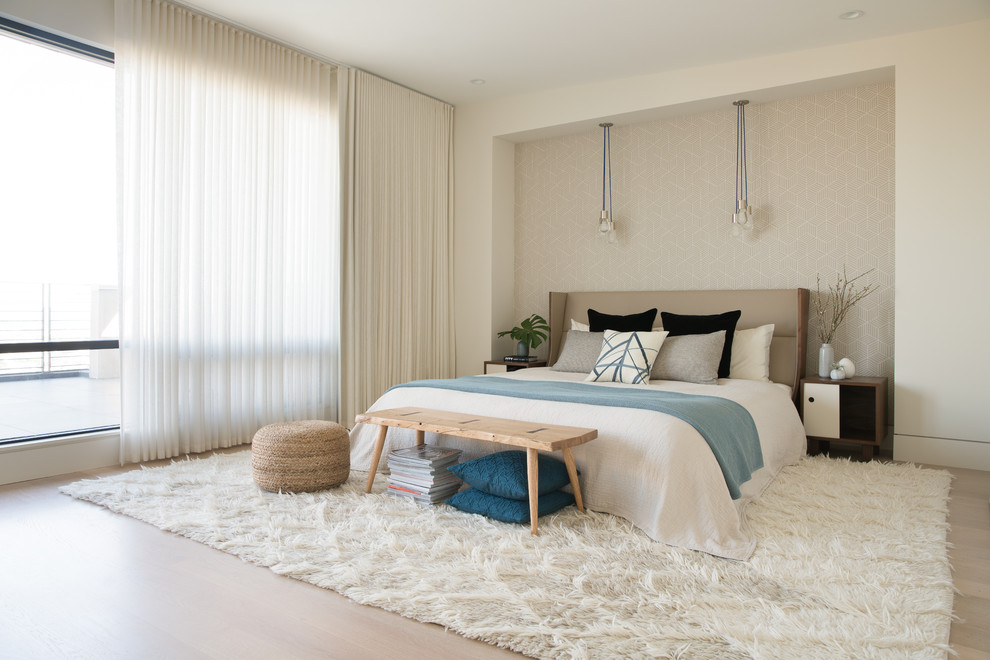 Large contemporary master bedroom in San Francisco with beige walls, light hardwood floors and beige floor.