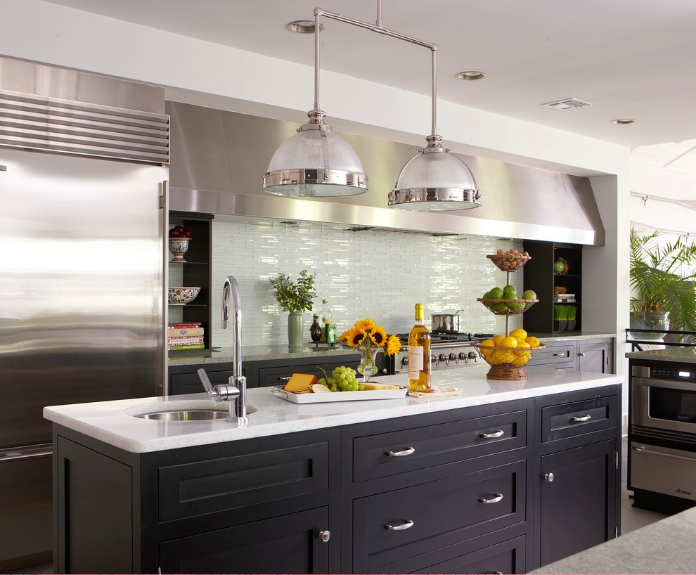 Inspiration for a beach style kitchen in New York with an undermount sink, shaker cabinets, black cabinets, white splashback, stainless steel appliances and glass tile splashback.