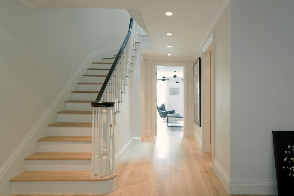 Photo of a mid-sized traditional wood curved staircase in New York with painted wood risers and wood railing.