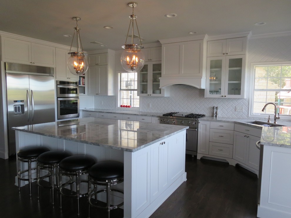 Example of a huge transitional u-shaped dark wood floor eat-in kitchen design in Austin with shaker cabinets, white cabinets, white backsplash, subway tile backsplash, stainless steel appliances, an island, an undermount sink and quartzite countertops