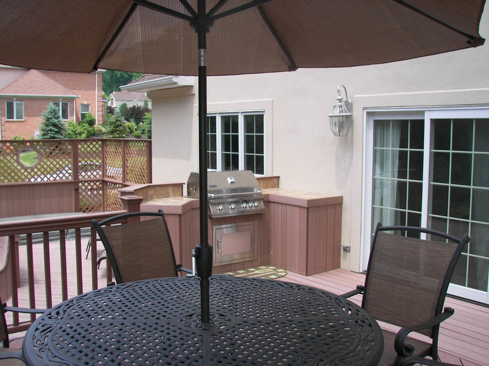 Example of a mid-sized transitional backyard outdoor kitchen deck design