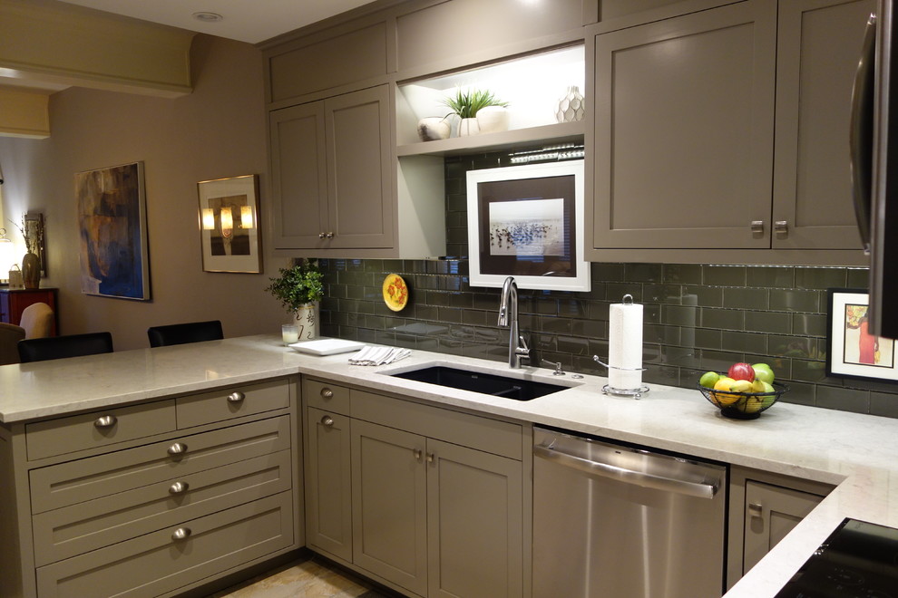 Small transitional u-shaped ceramic tile home design photo with an undermount sink, shaker cabinets, gray cabinets, quartz countertops, gray backsplash, glass tile backsplash, stainless steel appliances and a peninsula
