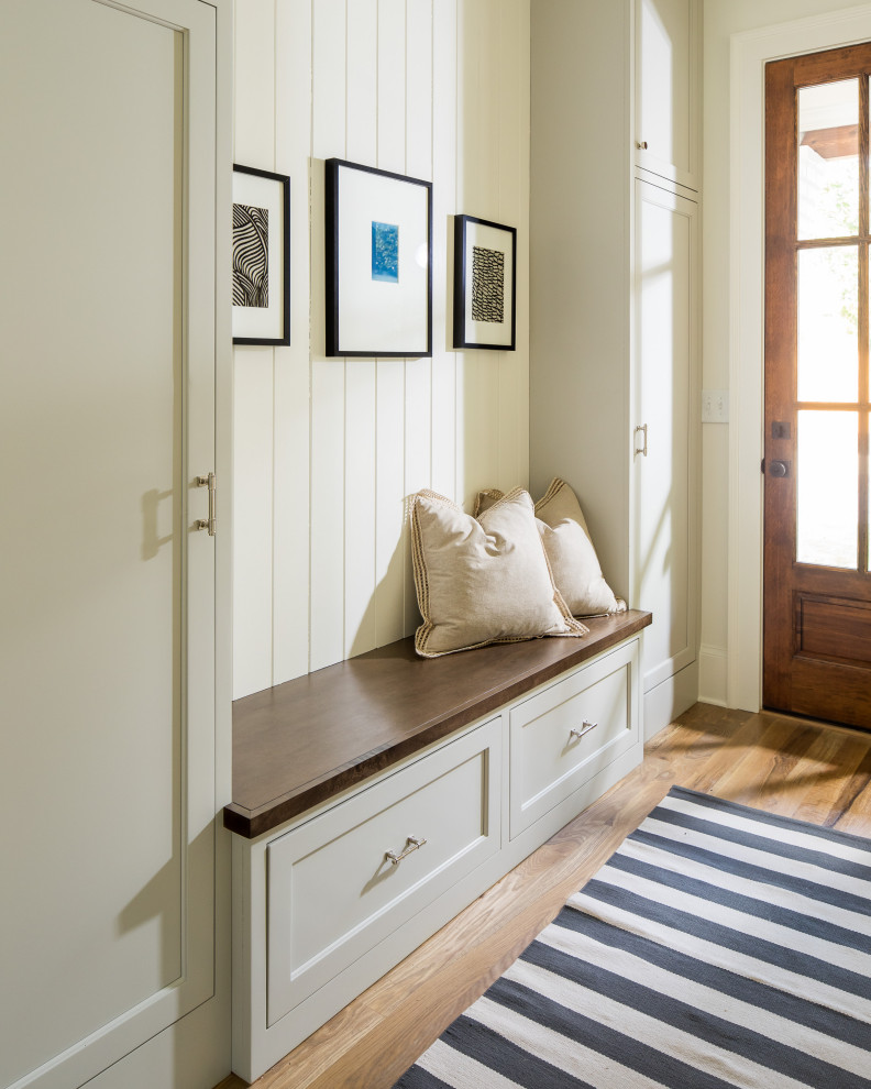 Mudroom - mid-sized transitional light wood floor and brown floor mudroom idea in Atlanta with white walls and a dark wood front door