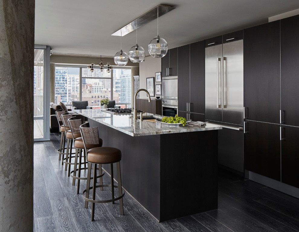 This is an example of a large contemporary single-wall open plan kitchen in Chicago with an undermount sink, flat-panel cabinets, dark wood cabinets, stainless steel appliances, dark hardwood floors, with island, marble benchtops and grey floor.