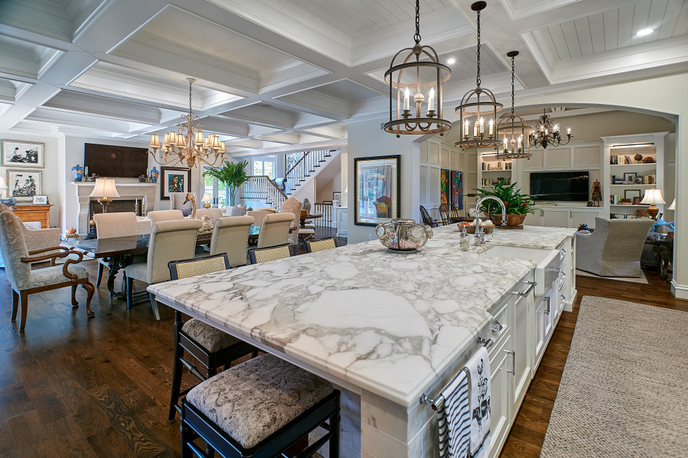 This is an example of a traditional kitchen in Cincinnati with a farmhouse sink, beaded inset cabinets, white cabinets, marble benchtops, white splashback, marble splashback, stainless steel appliances, medium hardwood floors, with island, brown floor, white benchtop and coffered.