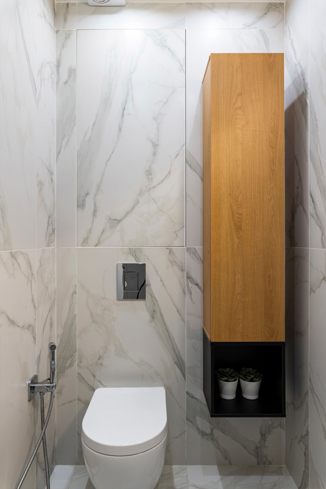 Cette photo montre un petit WC suspendu tendance avec des portes de placard marrons, des carreaux de porcelaine, un mur blanc, un sol en marbre, un lavabo suspendu, un sol blanc et meuble-lavabo suspendu.