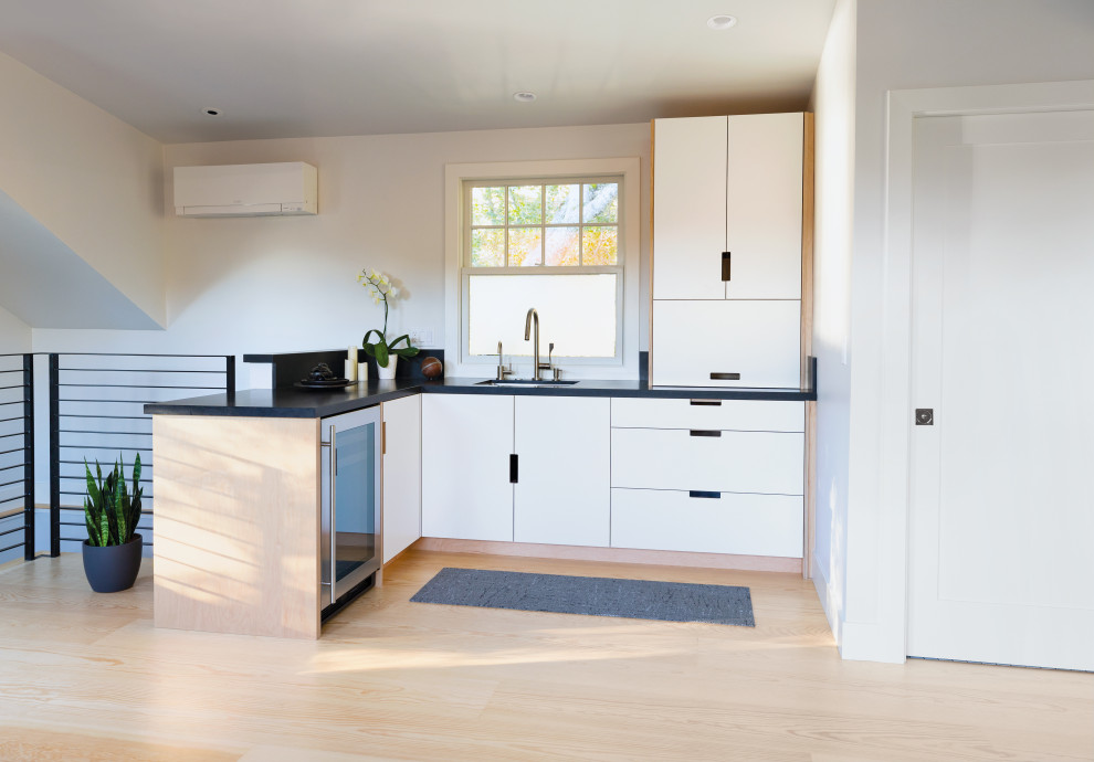 Example of a small minimalist l-shaped eat-in kitchen design in San Francisco with flat-panel cabinets, white cabinets, quartzite countertops, no island and black countertops