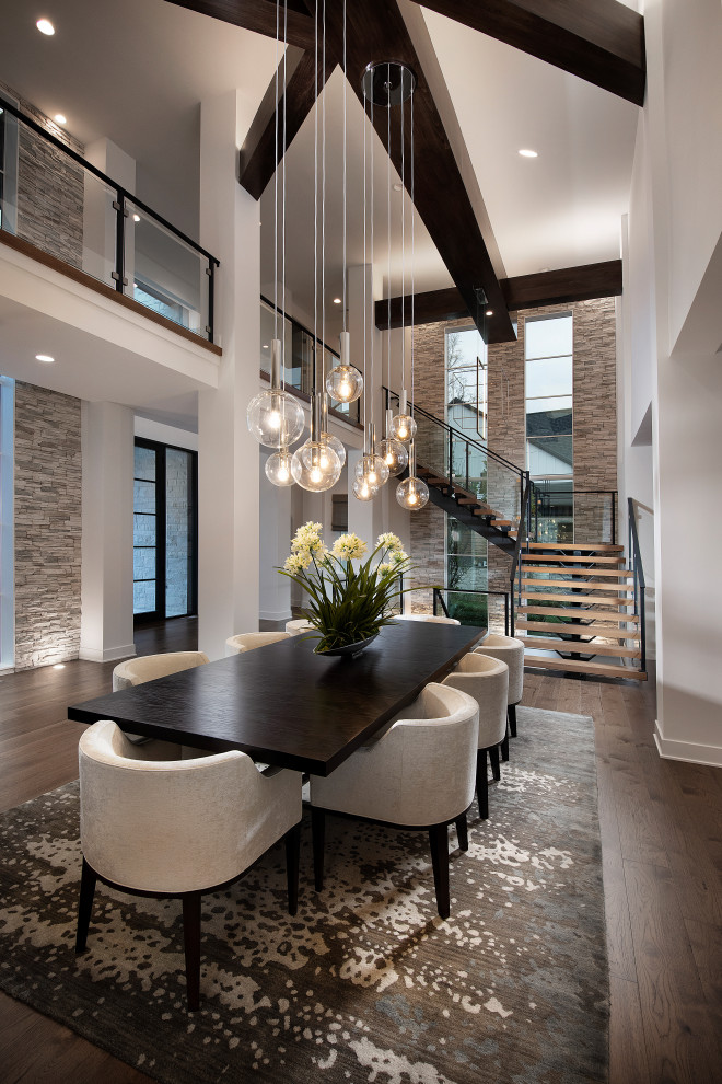 Expansive contemporary open plan dining in Nashville with white walls, medium hardwood floors and vaulted.