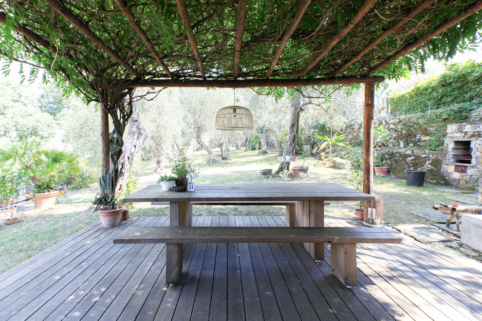 Inspiration for a mediterranean backyard deck in Milan with a pergola.