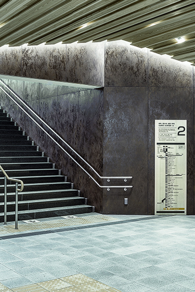 Esempio di un ampio ingresso o corridoio moderno con pareti marroni, pavimento in cemento e pavimento grigio