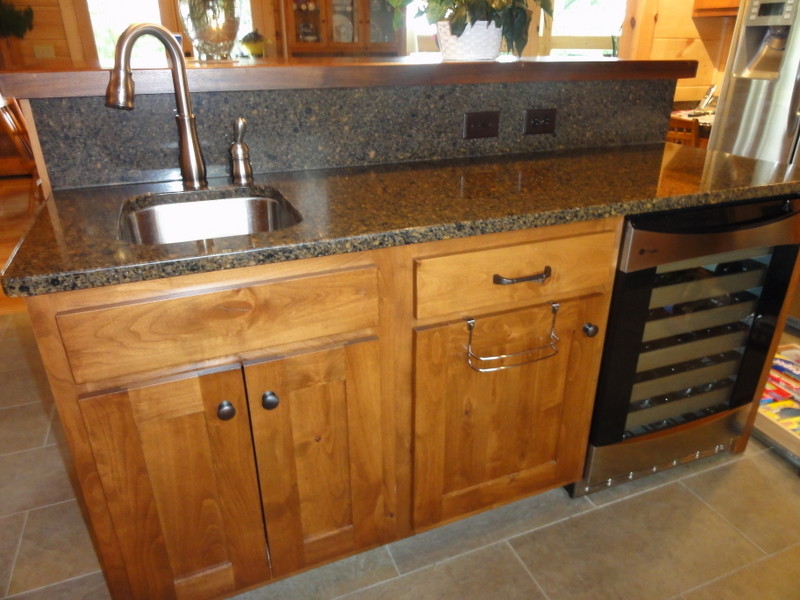 Inspiration for a rustic ceramic tile kitchen remodel with shaker cabinets, light wood cabinets, wood countertops and an island