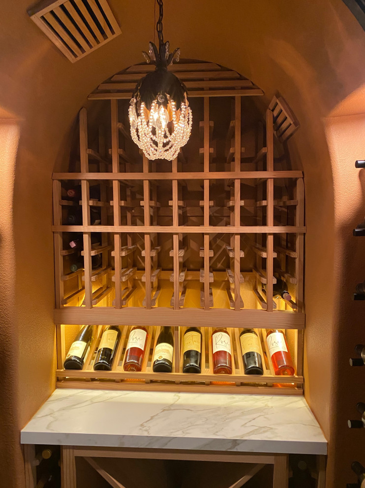 Inspiration for a small transitional wine cellar in Orange County with dark hardwood floors and display racks.