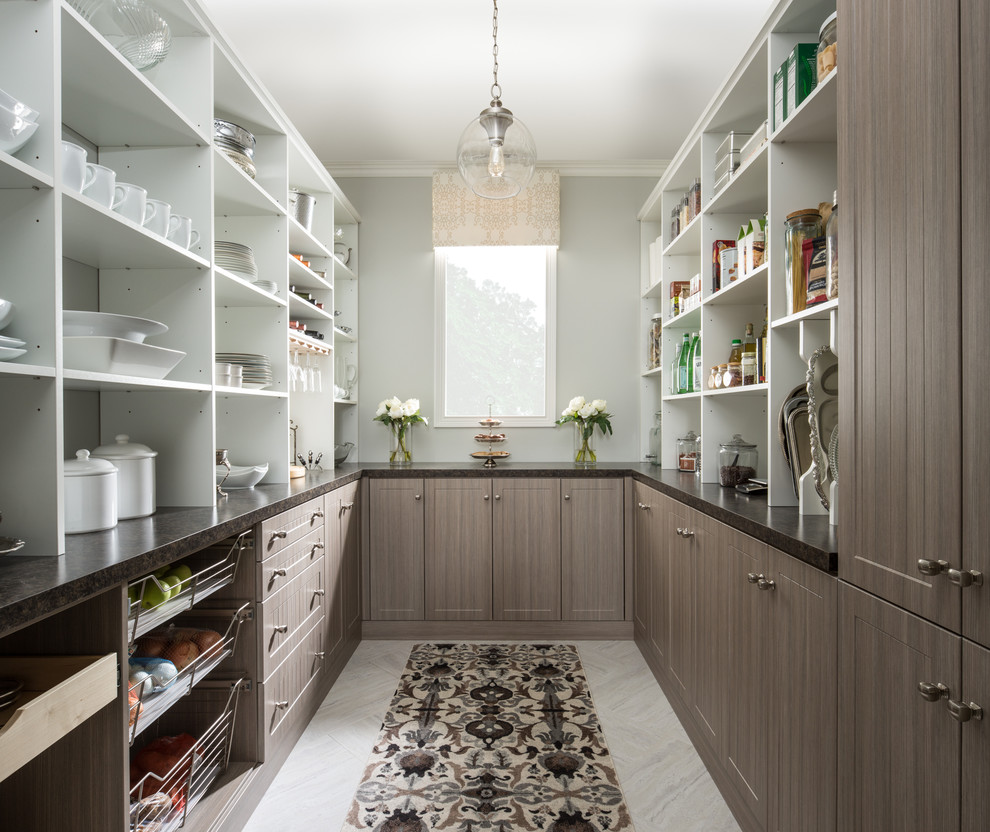 This is an example of a large transitional u-shaped kitchen pantry in Grand Rapids with brown cabinets, marble benchtops, blue splashback, stainless steel appliances and ceramic floors.