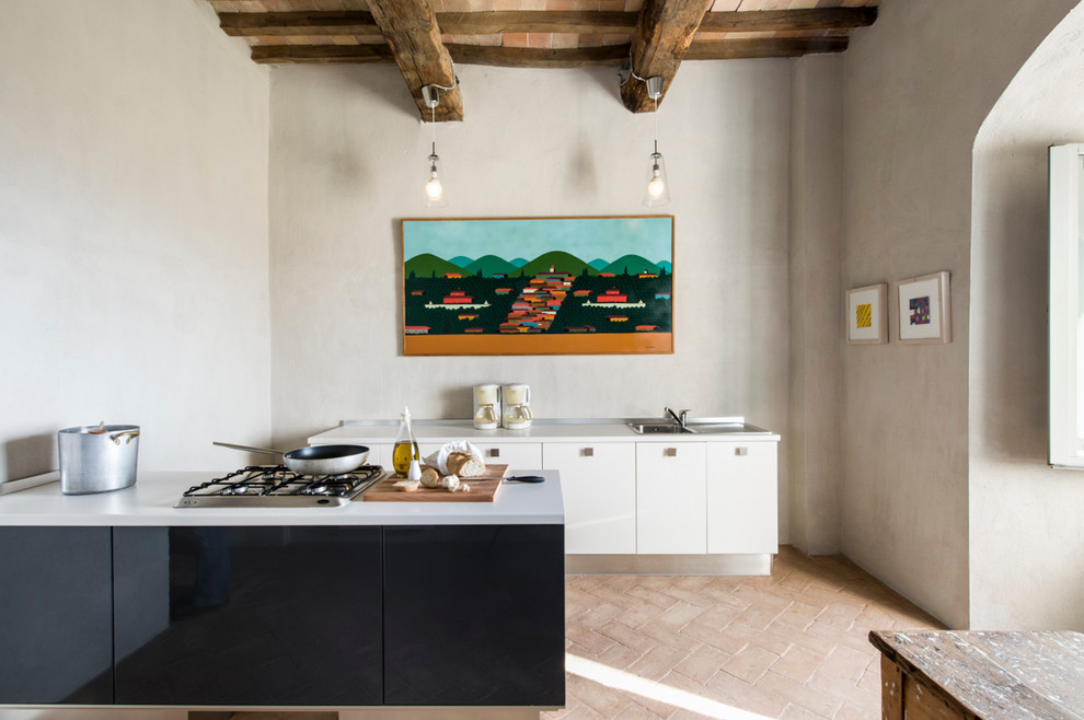 Inspiration for a modern kitchen in Florence with a drop-in sink, flat-panel cabinets, white cabinets, brick floors and with island.