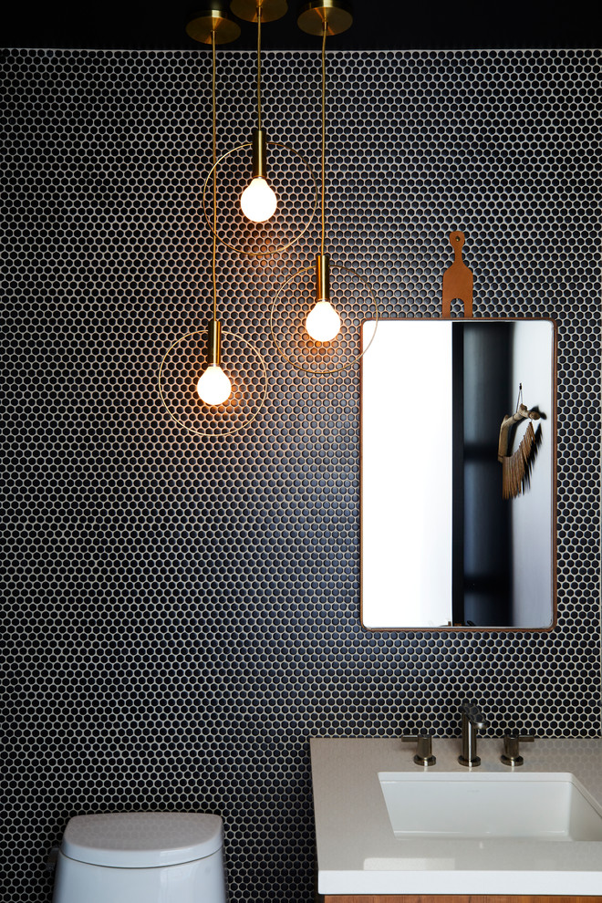 Powder room - contemporary black tile and mosaic tile powder room idea in Los Angeles with black walls, an undermount sink, medium tone wood cabinets and white countertops