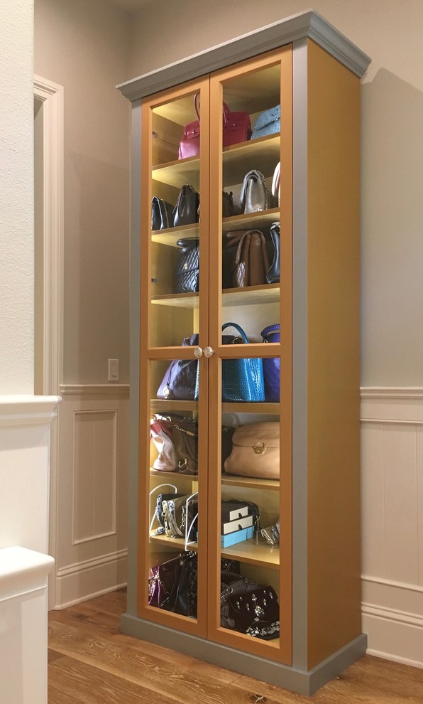 Design ideas for a mid-sized traditional women's dressing room in San Francisco with glass-front cabinets.