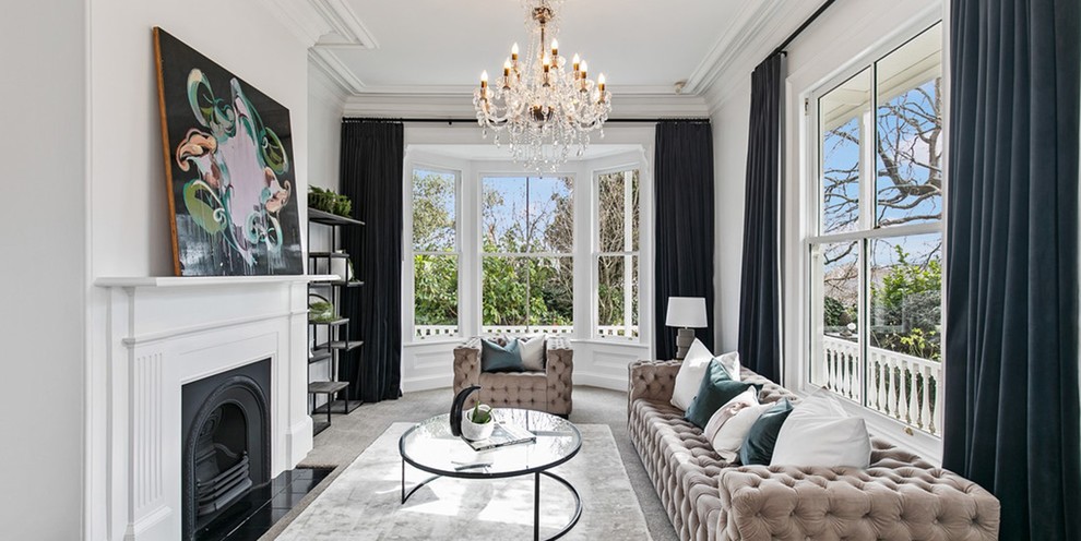 Large traditional formal enclosed living room in Auckland with white walls, carpet, a standard fireplace, a wood fireplace surround and grey floor.