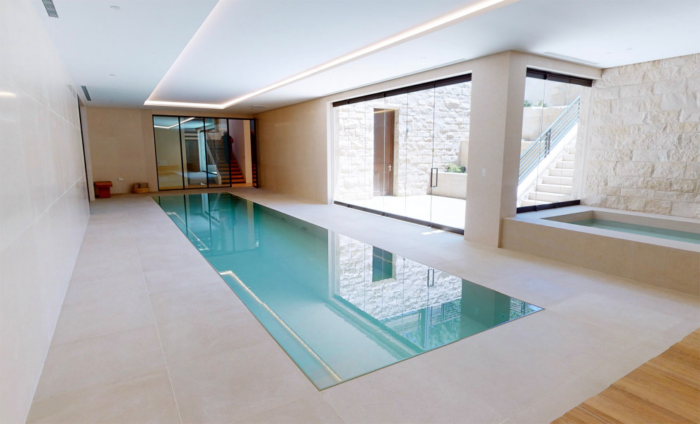 Immagine di una grande piscina coperta monocorsia minimalista rettangolare con una vasca idromassaggio e piastrelle