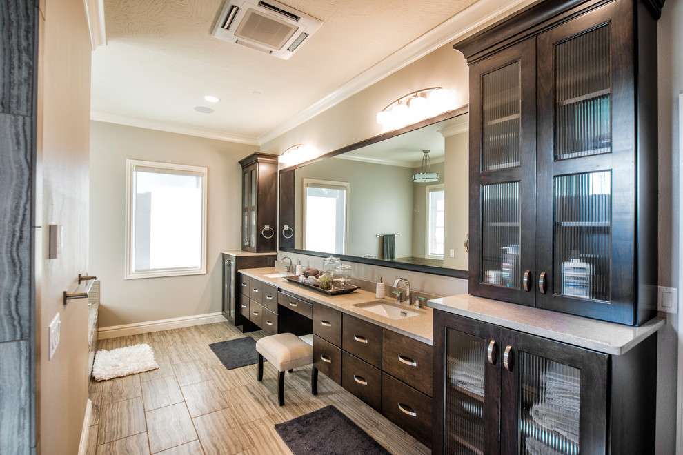 Large transitional master beige tile and porcelain tile porcelain tile bathroom photo with flat-panel cabinets, dark wood cabinets, beige walls, an undermount sink and limestone countertops