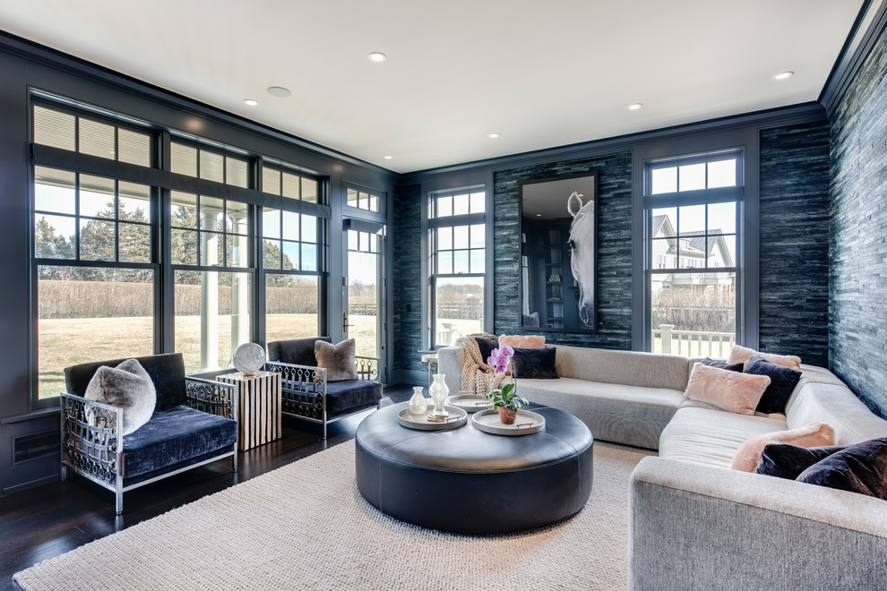 This is an example of a contemporary family room in New York with blue walls, dark hardwood floors and brown floor.