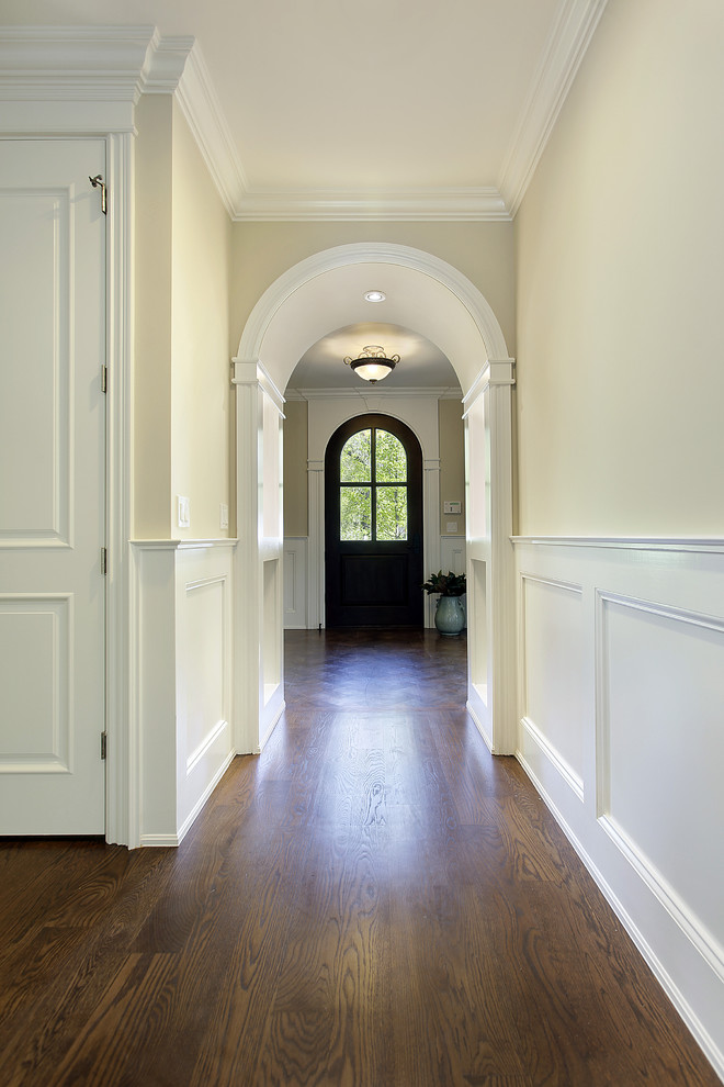 Design ideas for a mid-sized traditional entry hall in Chicago with beige walls, a single front door, medium hardwood floors and a dark wood front door.