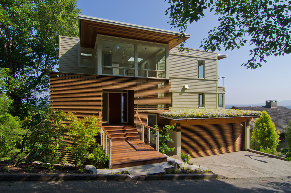 Design ideas for a mid-sized modern three-storey beige house exterior in Portland with mixed siding and a flat roof.
