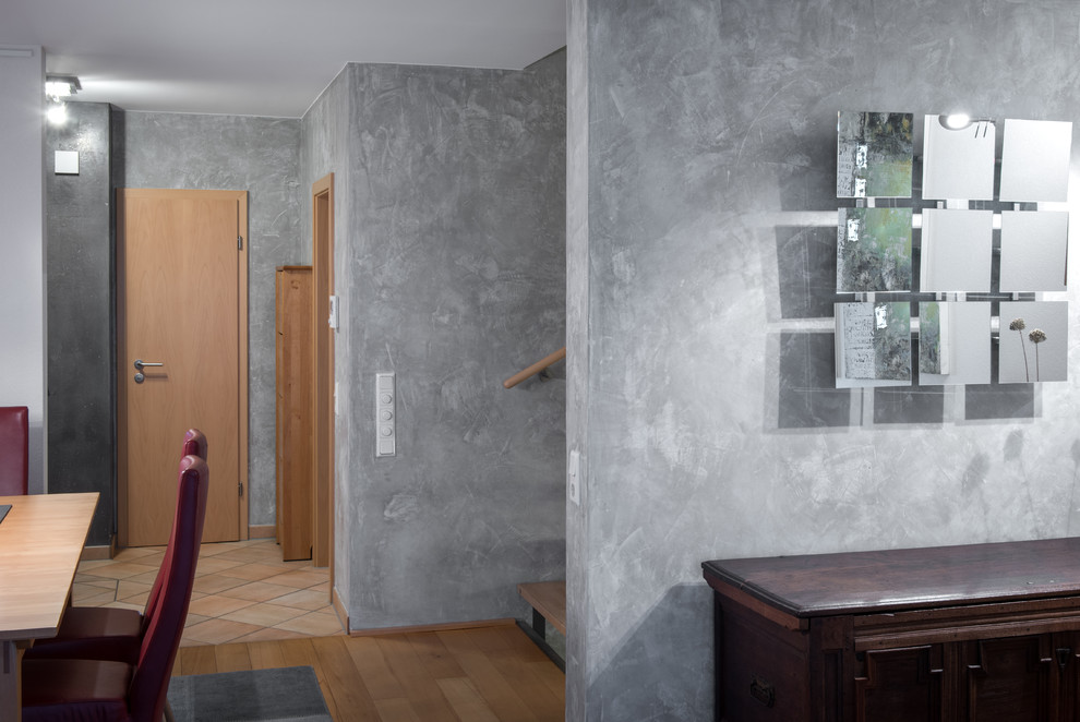 Großer Mediterraner Flur mit grauer Wandfarbe, braunem Holzboden und braunem Boden in Köln