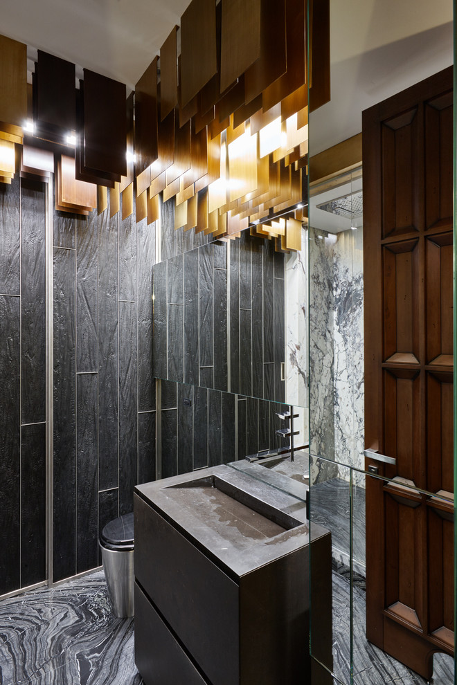 Photo of a small contemporary powder room in Moscow with marble, marble floors, an integrated sink, marble benchtops, grey floor, a two-piece toilet, black tile, flat-panel cabinets, black cabinets and black benchtops.