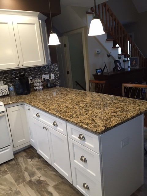 Mid-sized transitional u-shaped porcelain tile eat-in kitchen photo in Boston with an undermount sink, recessed-panel cabinets, white cabinets, granite countertops, multicolored backsplash, mosaic tile backsplash, white appliances and a peninsula