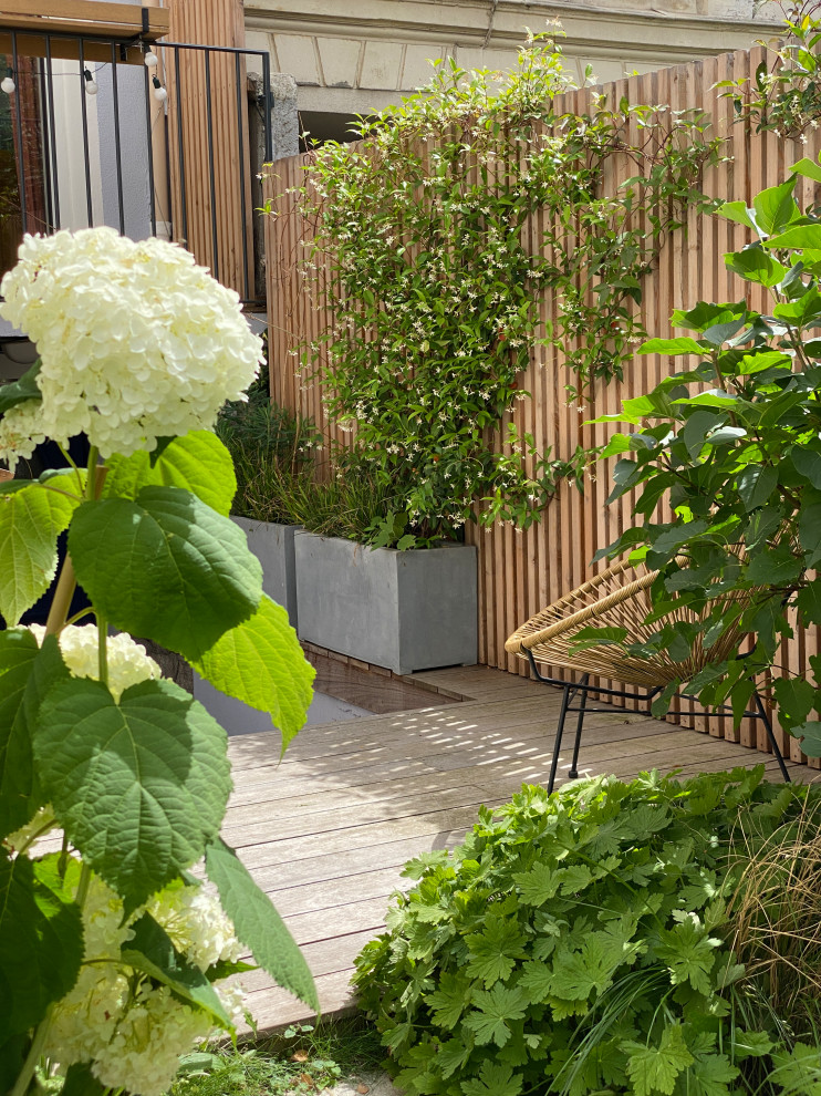 Immagine di un piccolo privacy in giardino country esposto a mezz'ombra davanti casa in primavera con pavimentazioni in pietra naturale e recinzione in legno