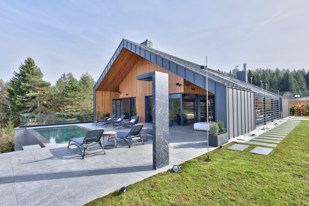 Diseño de piscina natural escandinava de tamaño medio a medida en patio trasero con paisajismo de piscina y suelo de baldosas