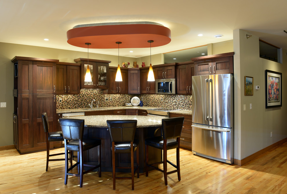Mid-sized transitional l-shaped light wood floor open concept kitchen photo with an undermount sink, shaker cabinets, dark wood cabinets, quartzite countertops, multicolored backsplash, mosaic tile backsplash, stainless steel appliances and an island