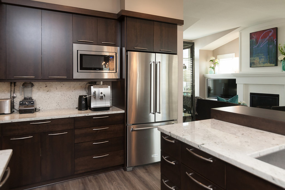 Inspiration for a large transitional l-shaped dark wood floor and brown floor eat-in kitchen remodel in Minneapolis with an undermount sink, flat-panel cabinets, dark wood cabinets, granite countertops, stone slab backsplash, stainless steel appliances, an island and white backsplash
