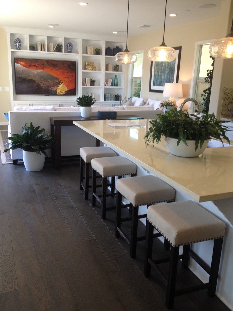 Trendy l-shaped brown floor kitchen photo with white cabinets and an island