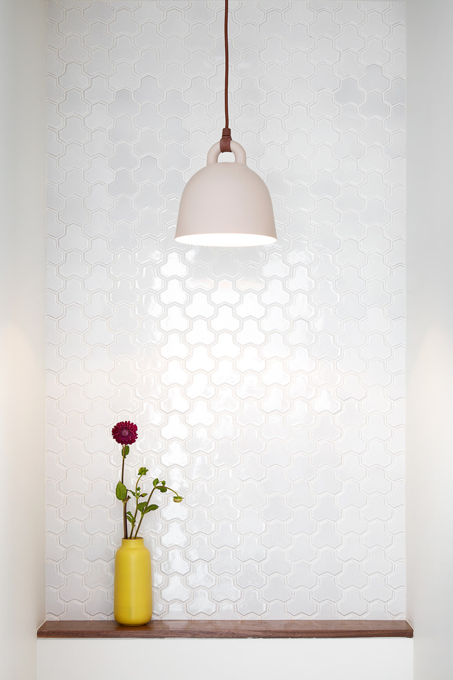 Powder room - small modern white tile and porcelain tile powder room idea in San Francisco with white walls and an undermount sink
