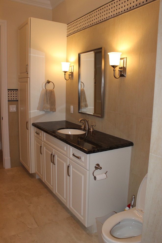 This is an example of a mid-sized transitional 3/4 bathroom in Miami with raised-panel cabinets, white cabinets, beige walls, travertine floors, an undermount sink and marble benchtops.