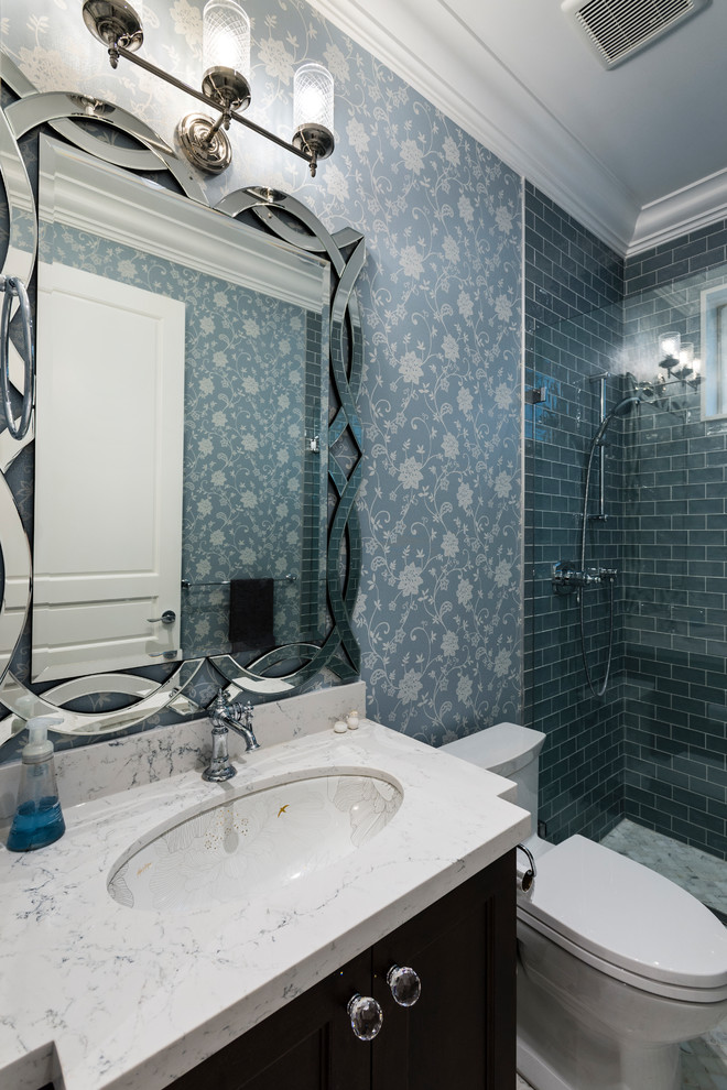 Inspiration for a small traditional 3/4 bathroom in Vancouver with recessed-panel cabinets, black cabinets, an alcove shower, a one-piece toilet, blue tile, glass tile, blue walls, porcelain floors, an undermount sink, engineered quartz benchtops, multi-coloured floor and a hinged shower door.