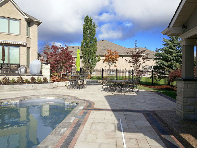 Example of a large transitional backyard stone and l-shaped hot tub design in Toronto