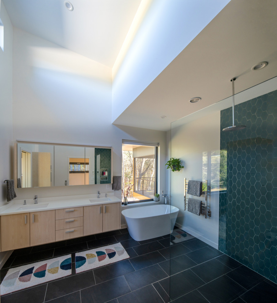 Идея дизайна: главная ванная комната среднего размера в стиле модернизм с плоскими фасадами, белыми фасадами, отдельно стоящей ванной, открытым душем, унитазом-моноблоком, синей плиткой, стеклянной плиткой, белыми стенами, полом из керамической плитки, врезной раковиной, столешницей из искусственного кварца, серым полом, открытым душем, белой столешницей, тумбой под две раковины и подвесной тумбой
