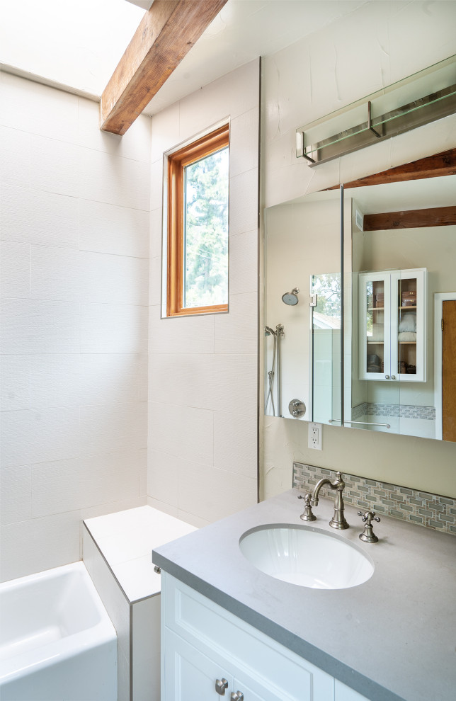 Inspiration for a modern master bathroom in Los Angeles with glass-front cabinets, white cabinets, a drop-in tub, a shower/bathtub combo, a one-piece toilet, white tile, white walls, concrete benchtops, grey benchtops, a single vanity, a built-in vanity and exposed beam.