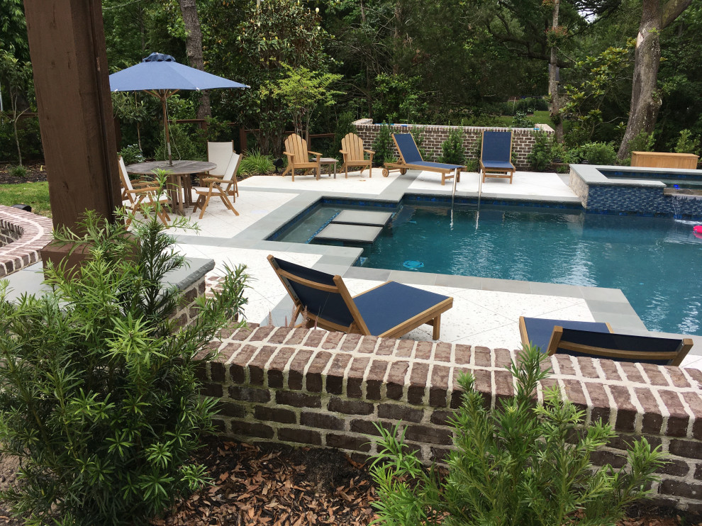 Design ideas for a mid-sized traditional backyard custom-shaped lap pool in Other with with a pool and natural stone pavers.