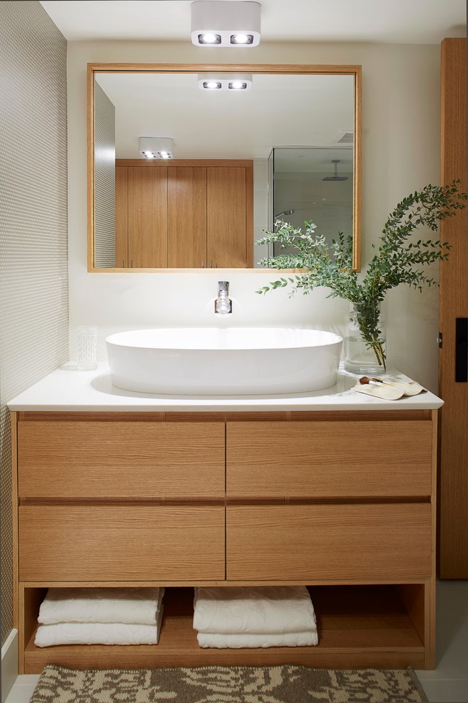 Photo of a mid-sized contemporary master bathroom in Montreal with flat-panel cabinets, light wood cabinets, engineered quartz benchtops, an open shower, a one-piece toilet, white tile, ceramic tile, white walls and ceramic floors.