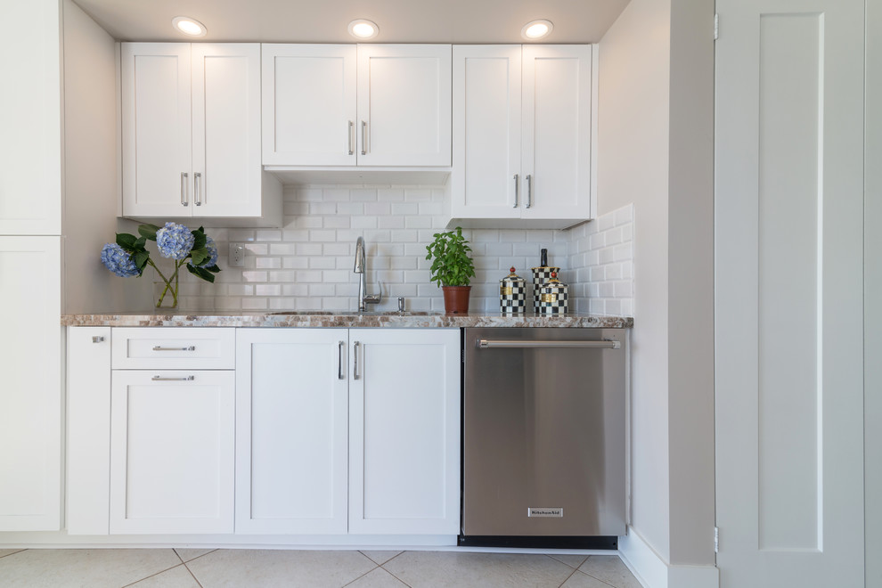 Eat-in kitchen - mid-sized transitional galley porcelain tile eat-in kitchen idea in Miami with an undermount sink, shaker cabinets, white cabinets, granite countertops, white backsplash, subway tile backsplash, stainless steel appliances and a peninsula