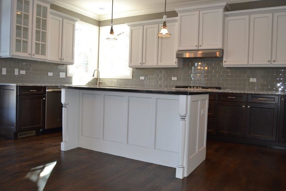 Enclosed kitchen - large transitional u-shaped dark wood floor and brown floor enclosed kitchen idea in Chicago with a double-bowl sink, shaker cabinets, white cabinets, gray backsplash, subway tile backsplash, stainless steel appliances and an island