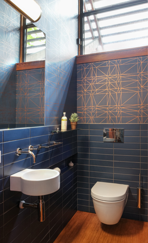 Mittelgroßes Retro Duschbad mit blauen Schränken, Wandtoilette, blauen Fliesen, Zementfliesen, dunklem Holzboden, braunem Boden, Einzelwaschbecken, schwebendem Waschtisch, Holzdecke und Tapetenwänden in San Francisco