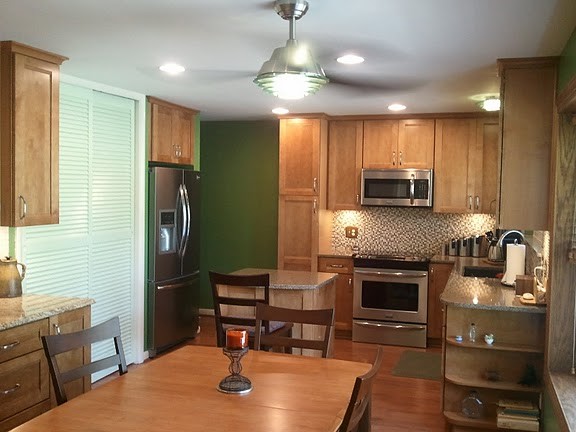 Inspiration for a mid-sized transitional u-shaped medium tone wood floor eat-in kitchen remodel in Cincinnati with an undermount sink, flat-panel cabinets, medium tone wood cabinets, quartz countertops, multicolored backsplash, mosaic tile backsplash, stainless steel appliances and an island